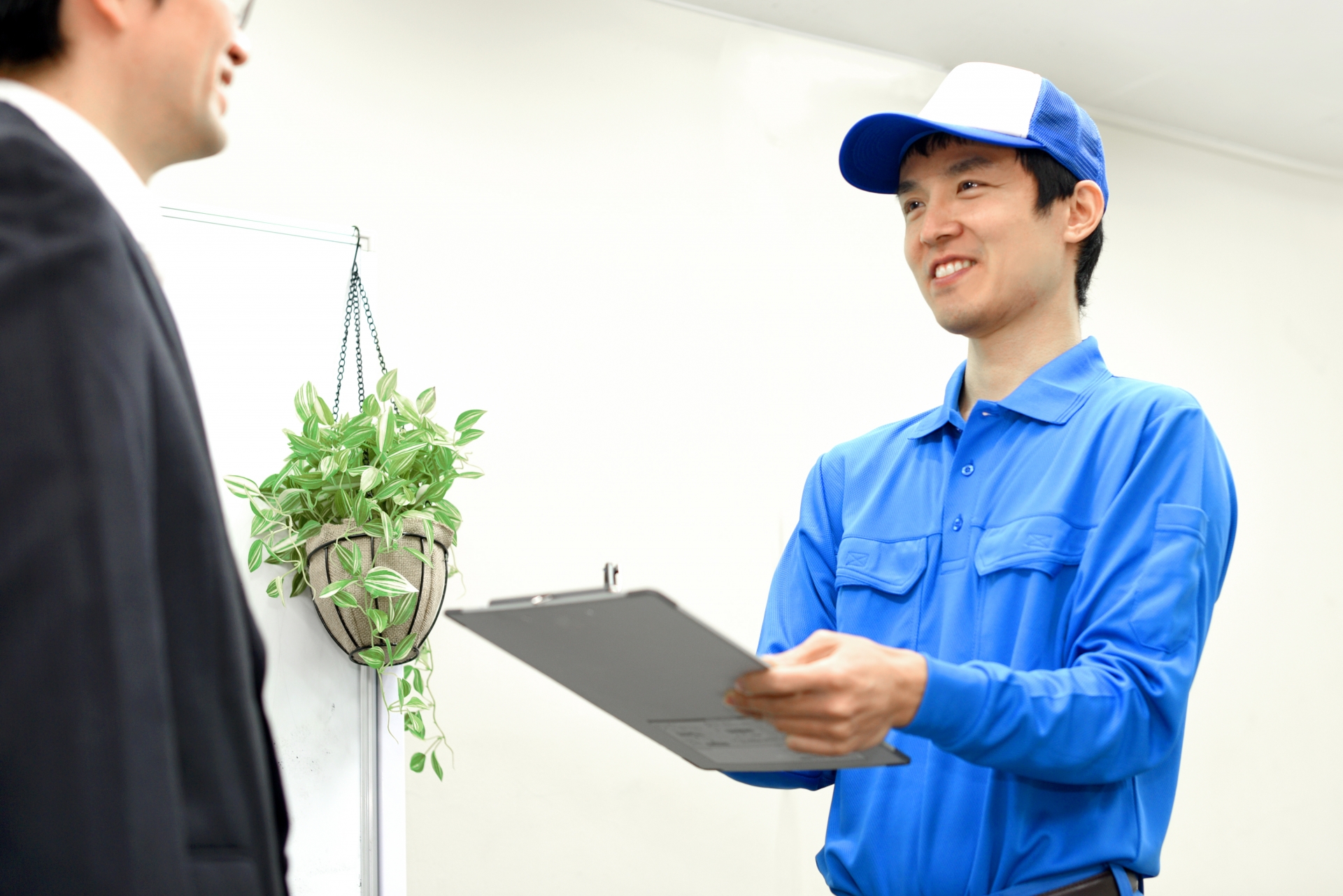 作業員が笑顔で見積もり対応するイメージ